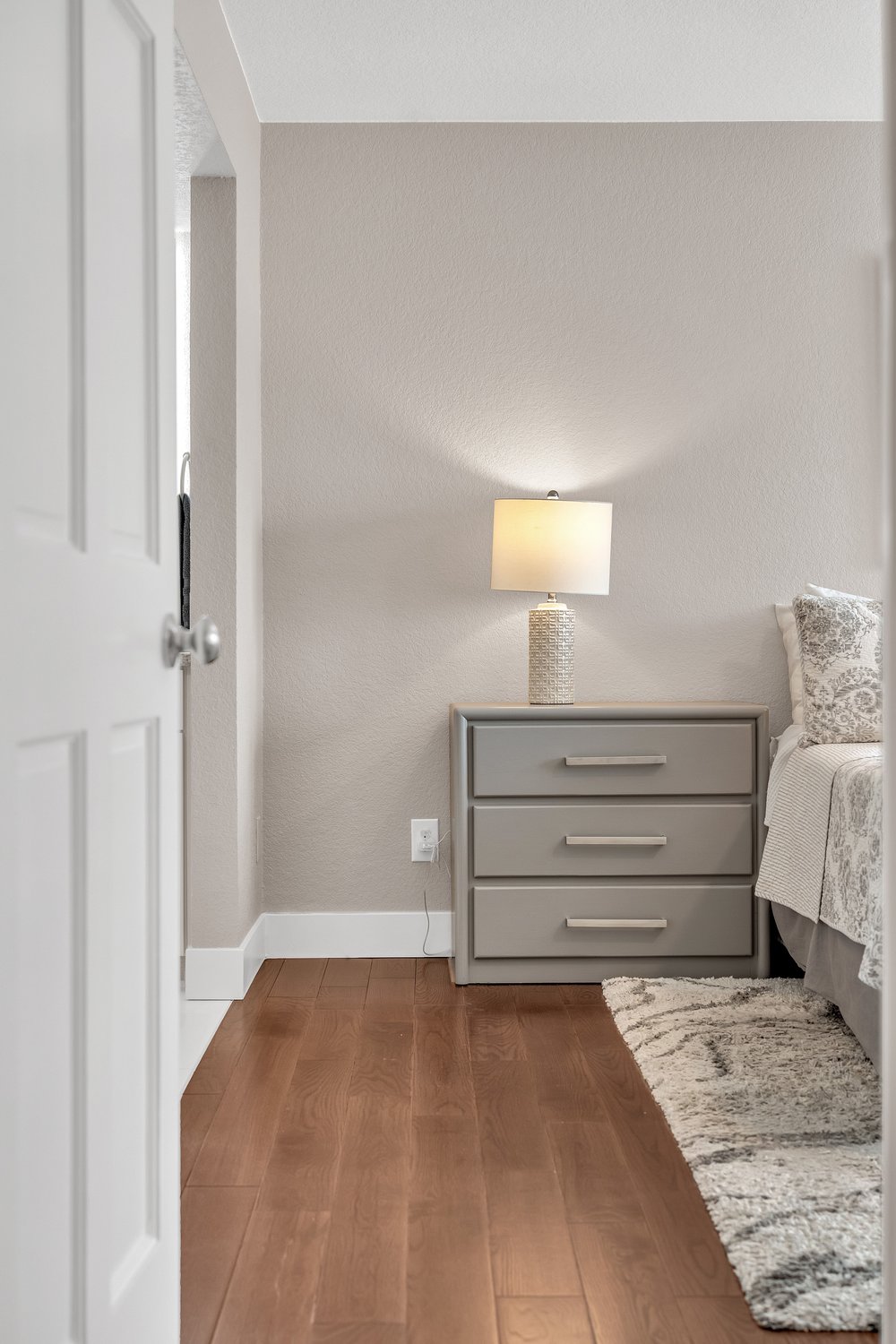 Master bedroom detail shot showing nightstand, hardwood floors and doorway - Highlands Ranch
